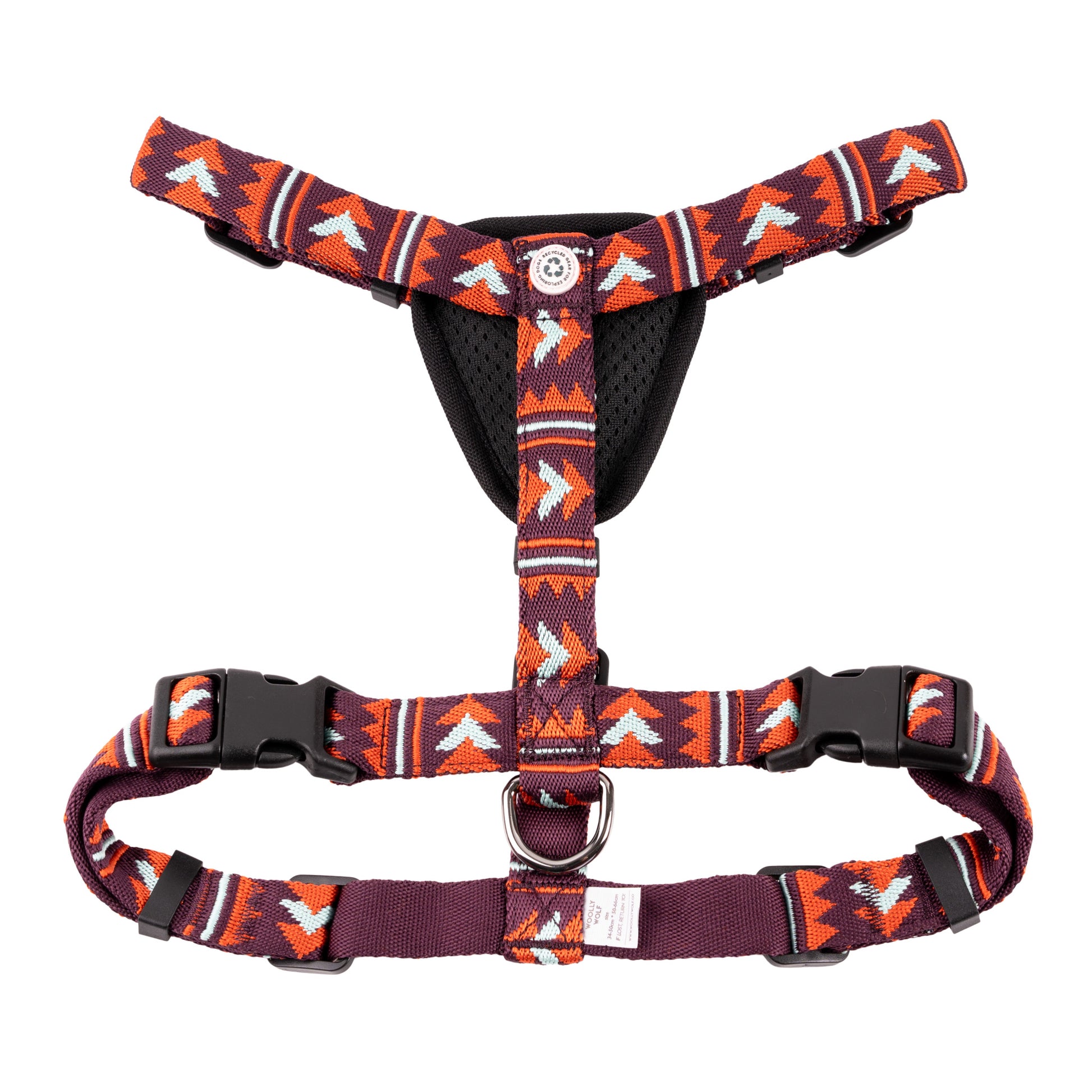 Dog harness with colorful geometric pattern in red, orange, and purple, featuring black buckles and padding.