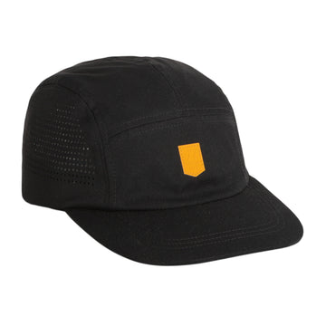 The Alpha 360 Tech Cap Black is a five-panel black cap with a curved brim, featuring a small yellow rectangular patch on the front and ventilation holes on the side panels.