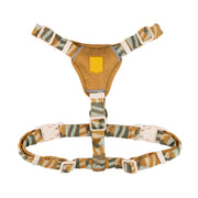 Camouflage-patterned dog harness with adjustable straps and plastic buckles, laid flat on a white background.