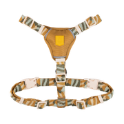 A camouflage-patterned dog harness with adjustable straps and plastic buckles on a white background.