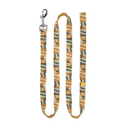 Patterned dog leash with a yellow, white, and green abstract design and a silver metal clasp.