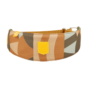 Wide dog collar with a geometric brown, tan, and green pattern and a yellow Woolly Wolf logo patch.