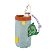 Light blue fabric dog waste bag holder with a brown rim, carabiner clip, and green bag partially dispensed.