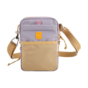 Small crossbody bag with a beige front pocket, lilac body, and adjustable tan strap, on a white background.
