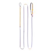 A lavender and tan dog leash with adjustable straps and a metal clip, laid flat on a white background.