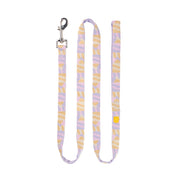Pastel-colored dog leash with a metal clasp, featuring a purple and yellow abstract pattern, laid flat.